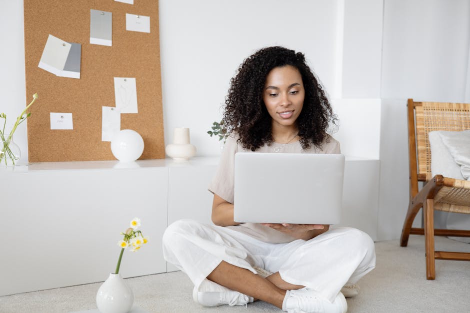 pexels photo 7552374 7552374 Young woman with curly hair working on her laptop in a cozy home setting, exuding confidence and focus.